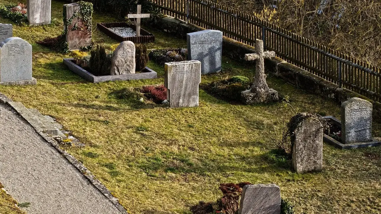 Cmentarz z nagrobkami i krzyżami. Zastanawiam się, jak głęboko zakopuje się urnę, by zapewnić jej spokój.
