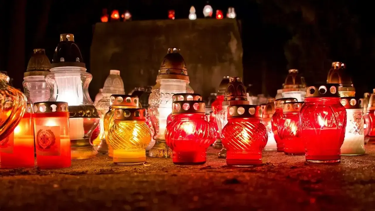 Płonące znicze na cmentarzu. Warto pamiętać, dlaczego nie wolno palić zniczy na pogrzebie, by nie zakłócać spokoju zmarłych.