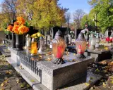 Jesienne zaduszki na cmentarzu. Zastanawiasz się, ile kosztuje miejsce na cmentarzu? Kwiaty i znicze na grobach.