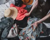 Przesądy związane z rzeczami po zmarłych, jak buty, mogą budzić niepokój. Na zdjęciu widać stos ubrań, wśród nich kapelusze i swetry.
