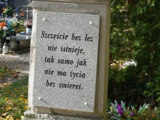 Kamienna płyta z cytatem o życiu i śmierci na cmentarzu, gdzie odbywa się pochówek urny.