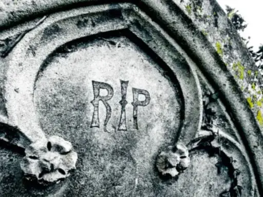 Napis "RIP" na kamiennym pomniku, co oznacza "Requiescat in pace" (Niech spoczywa w pokoju), symbolizuje wieczny odpoczynek.