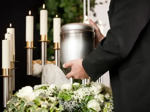 Uroczystość pożegnania, gdzie można rozsypać prochy po kremacji. W tle świece i kwiaty.