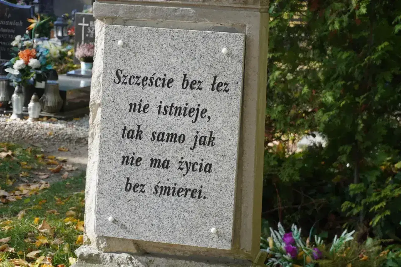 Kamienny grobowiec na urny z wyrytym cytatem: